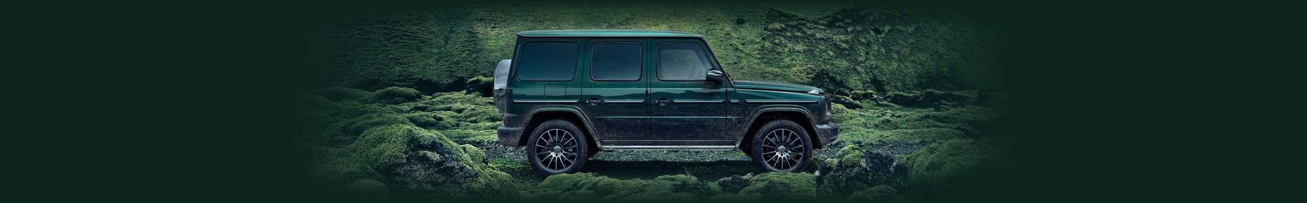 Green Mercedes-Benz G-Class model parked on gravel road