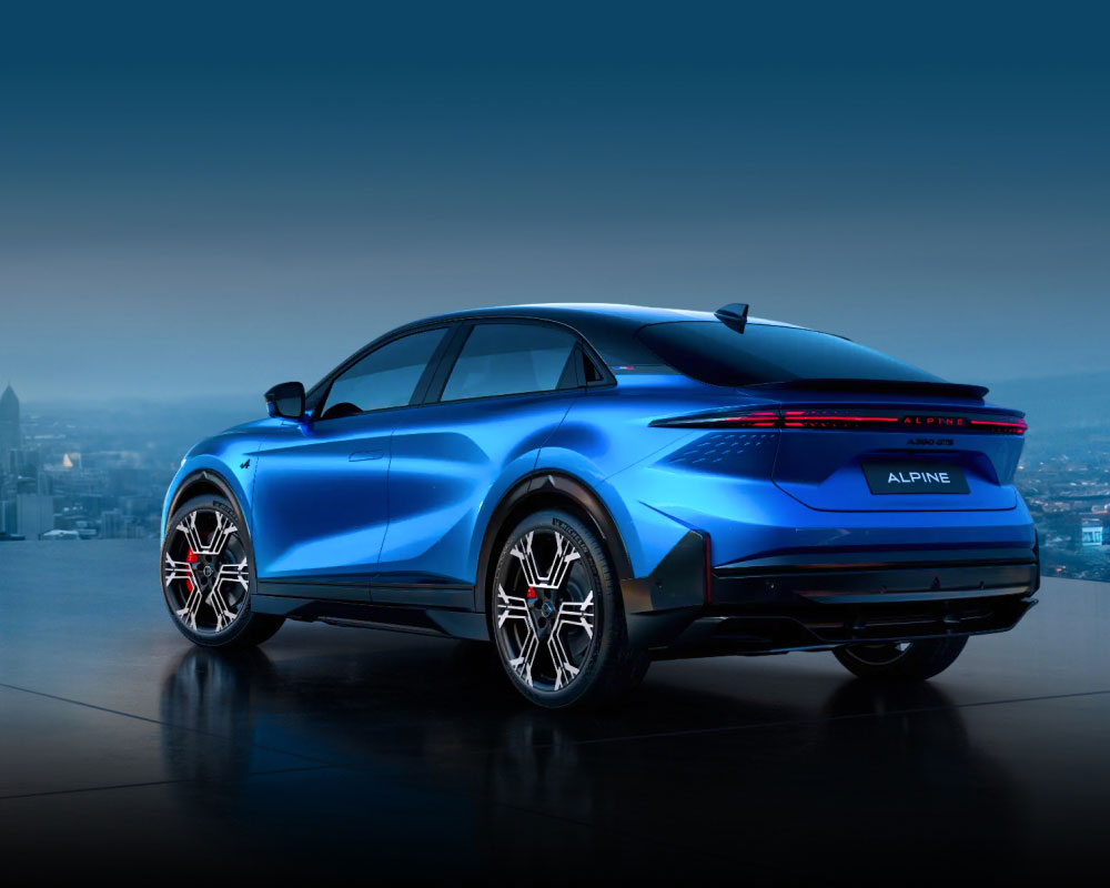 Rear side view of a blue Alpine A390 against a city backdrop