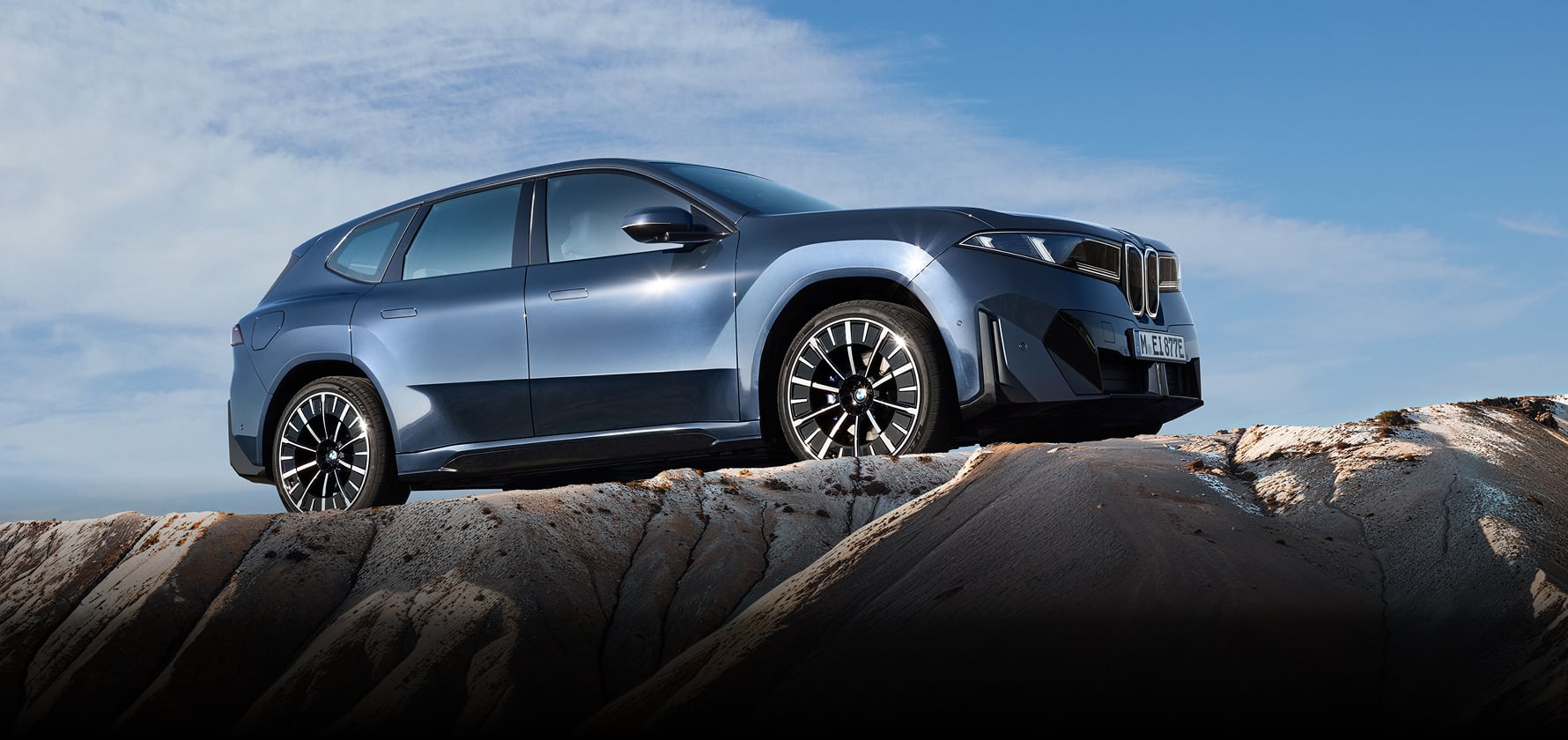 Side angled view of BMW iX3 on top of mountain