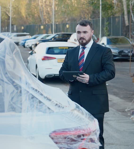 Bodyshop manager beside car