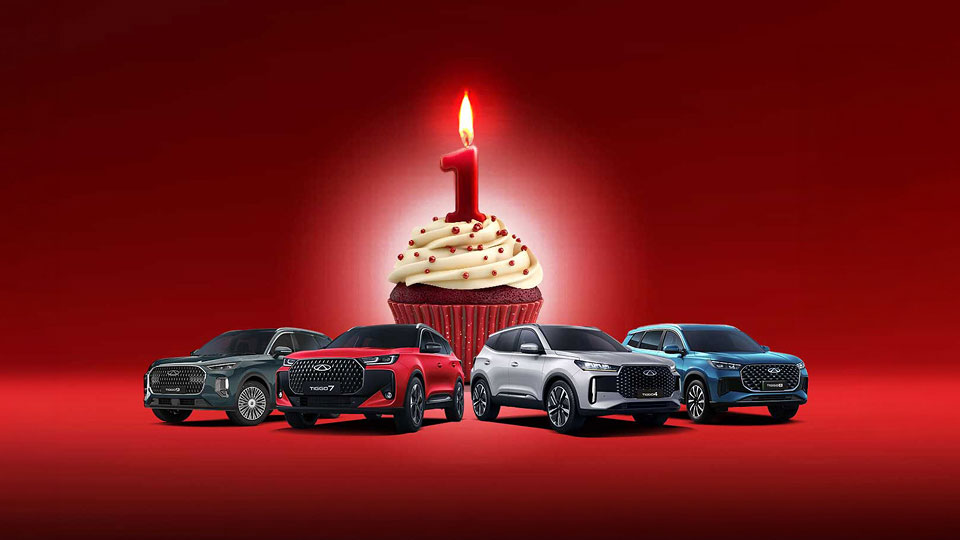 Chery model range infront of a giant cupcake with a number 1 candle on top