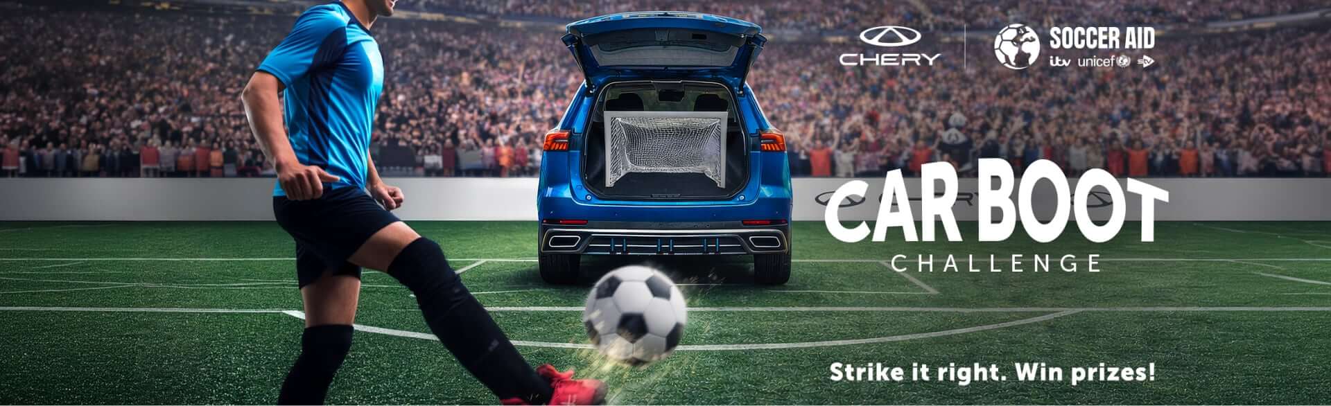 A soccer player kicks a ball towards a blue car with its boot open containing a goal net, in a stadium filled with cheering fans