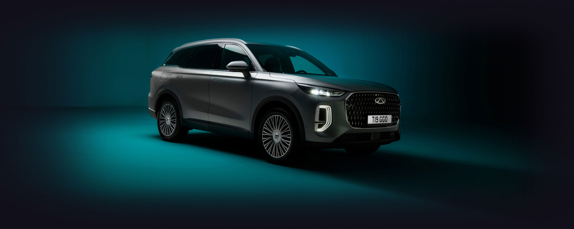 Chery Tiggo 9 in dark silver against a dark green background