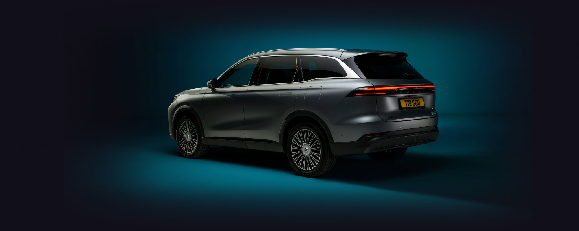 Chery Tiggo 9 rear side in dark silver against a dark green background