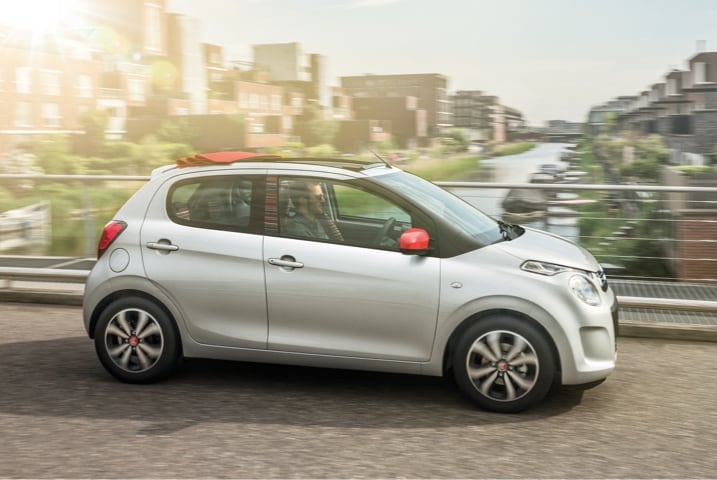 Silver Citroen C1 driving on city street