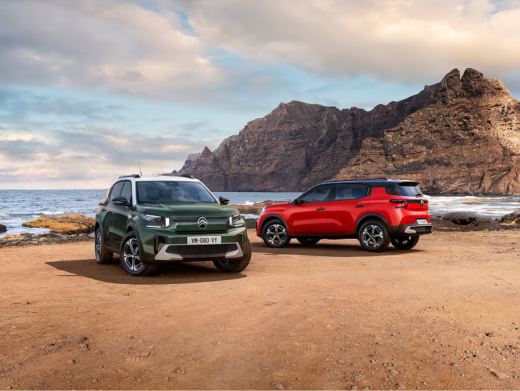 A green and an orange Citroen C3 Aircross on the beach
