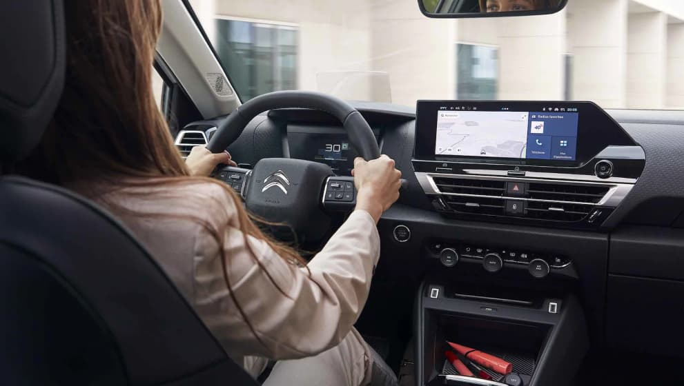 Interior shot of dashboard and woman driving the Citroen C4 and 