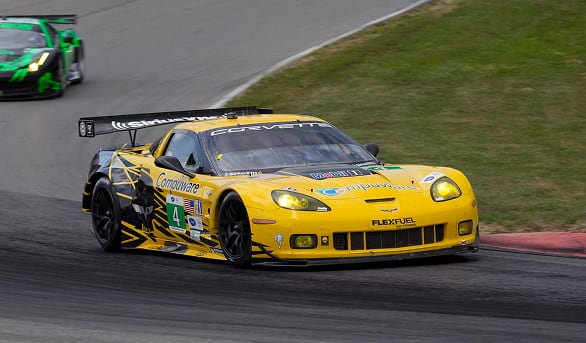 Yellow Corvette race car speeding on a curved race track