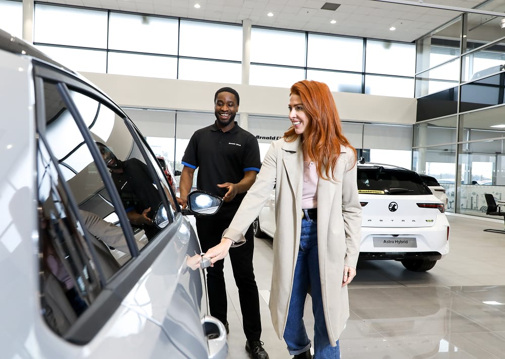 Arnold Clark Product Consultant showing customer a new car