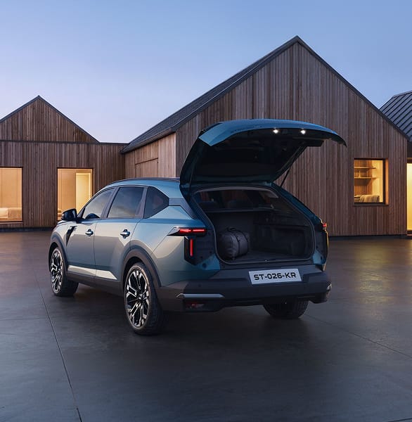 Dacia Striker parked outside modern wooden house with tailgate open