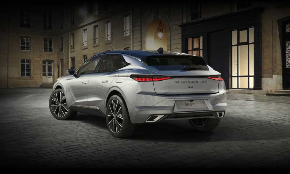 Rear side view of DS No4 in a light metallic colour on a dark Parisian street