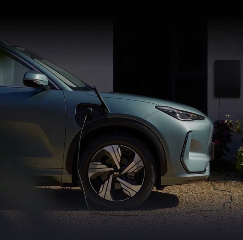 Front side-on view of metallic green Geely EX5