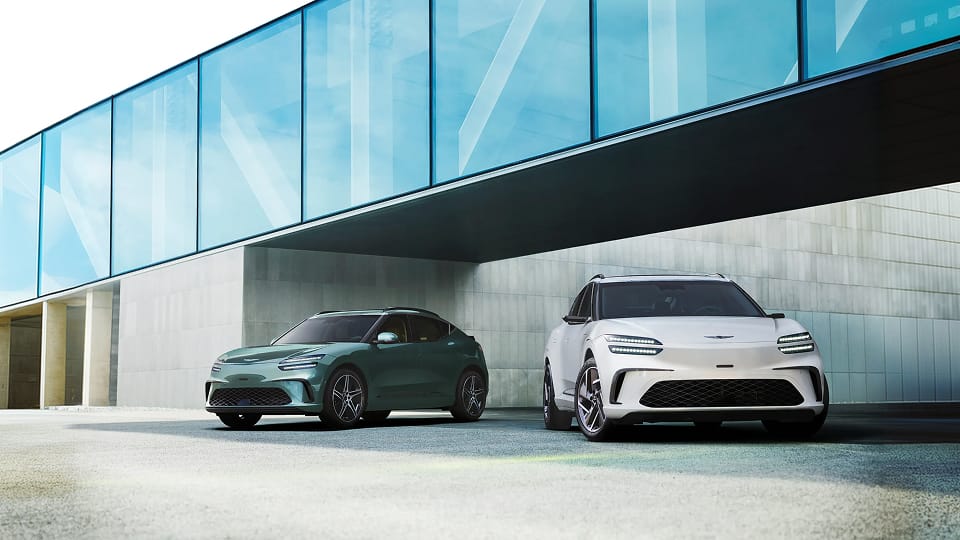 Green and white Genesis GV60's parked outside modern office building