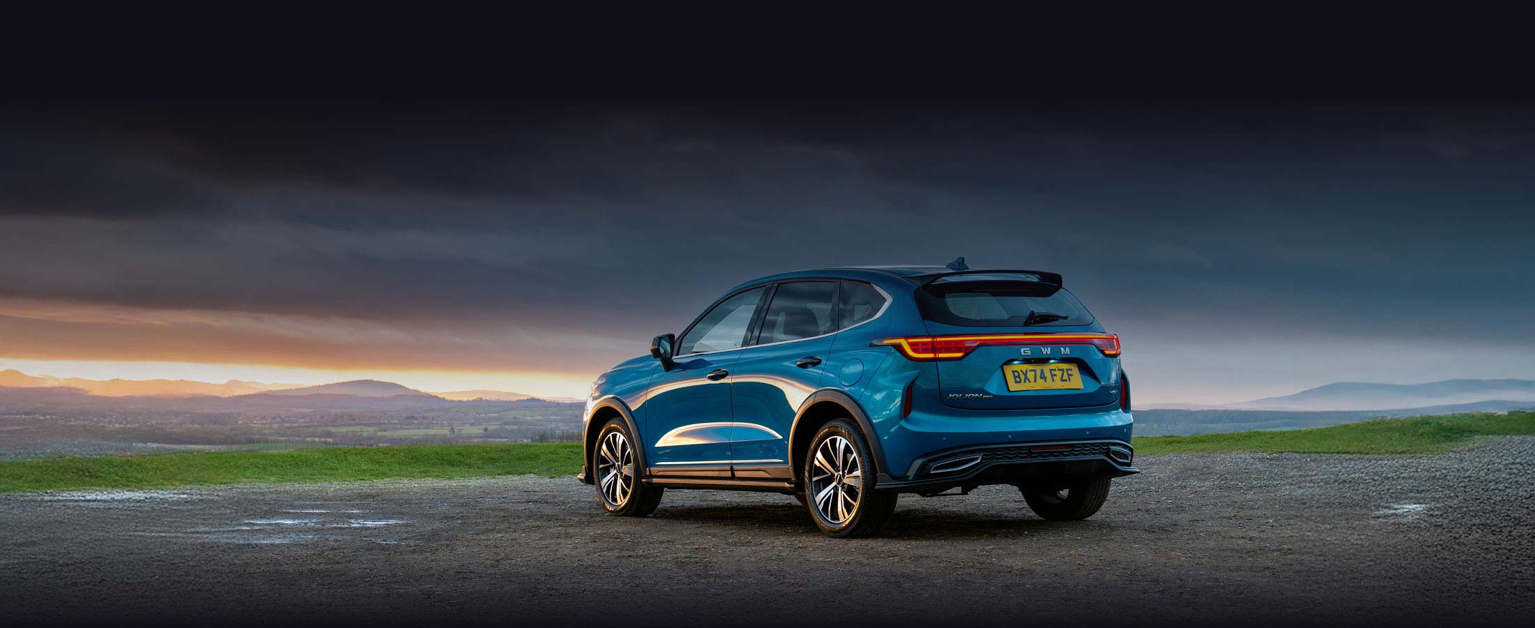 Rear side view of Haval Jolion at the side of a country road