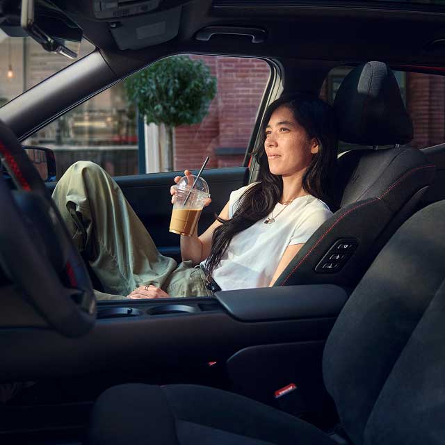 Passenger drinking coffee in front passenger seat of Hyundai IONIQ 3