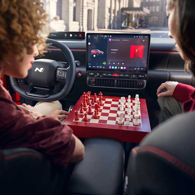 Two people playing chess in the front seats of the Hyundai IONIQ 3