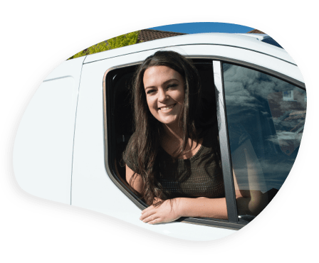 Young woman leaning out of a van window, smiling