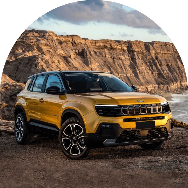 Angled front shot of yellow Jeep Avenger with rocky background