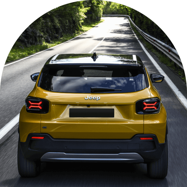 Rear shot of yellow Jeep Avenger driving on road