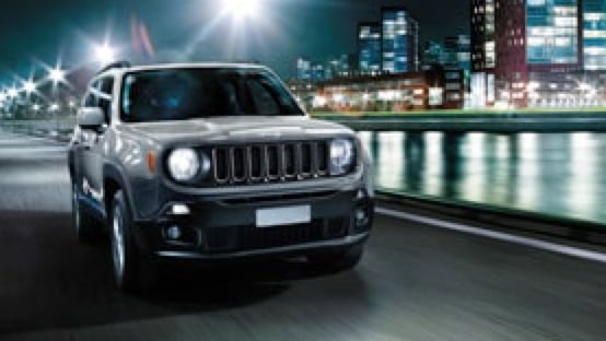 Jeep Renegade driving along a city river.