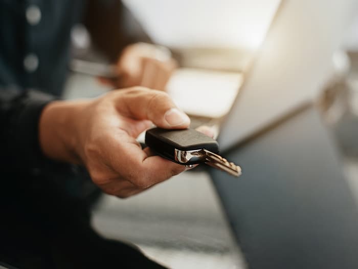 Hand holding out car key