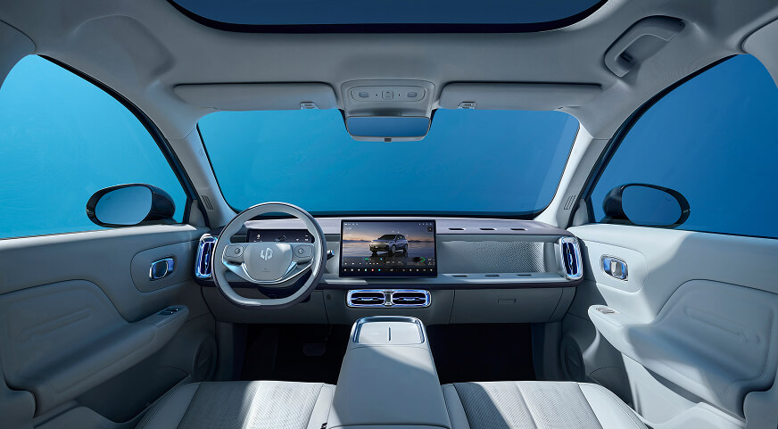 Interior view of a Leapmotor B10 featuring a digital dashboard, large central touchscreen, light-coloured seats, and panoramic sunroof