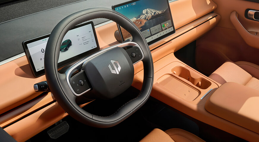 Leapmotor C10 interior featuring a modern steering wheel with a logo, dual digital displays, and tan leather seats and dashboard