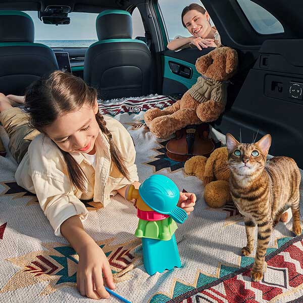 Child playing with toys in car with parent smiling in background