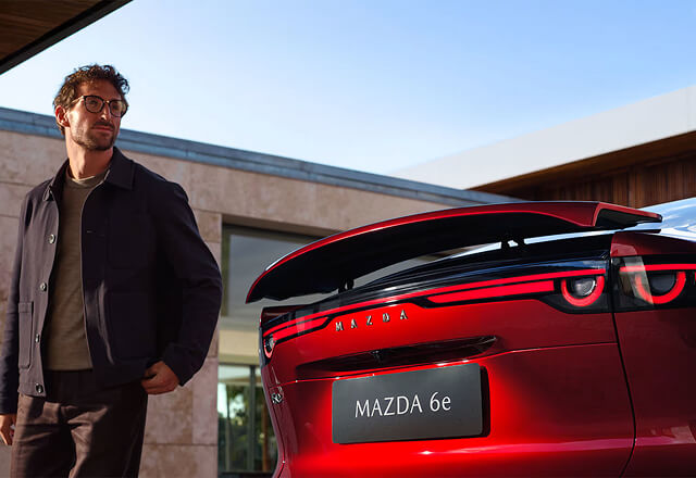 Mazda6e electric rear spoiler with person standing nearby