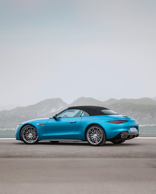 Side angled view of Mercedes AMG-SL car parked outside mountainous background