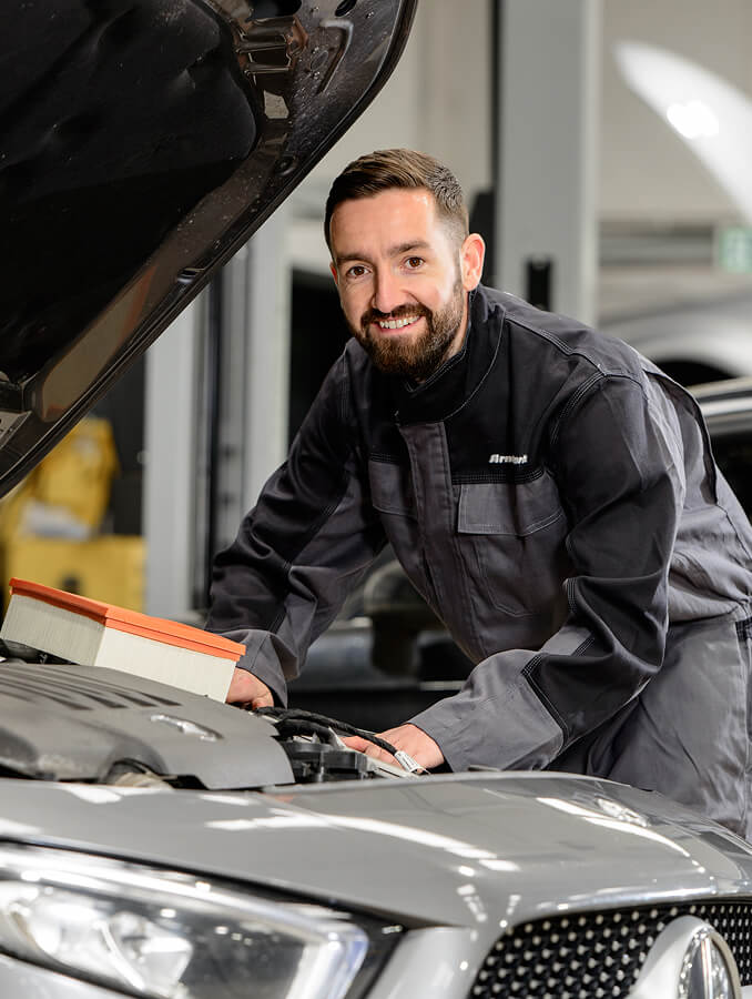 Mechanic working under bonnet of car
