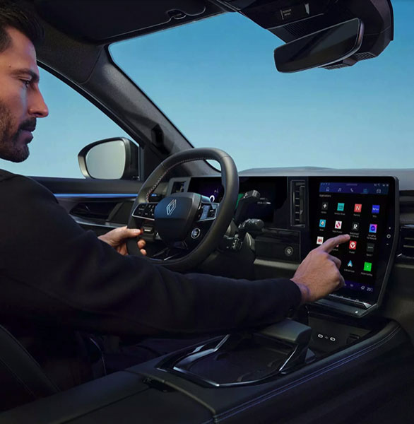 View of Renault Austral driver cockpit with young man selecting options on touchscreen