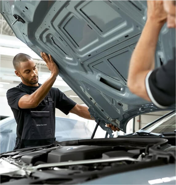 Staff working under bonnet of vehicle