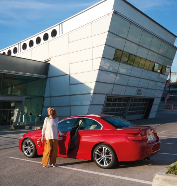 Rear angled view of BMW vehicle with customer and BMW service centre in the background