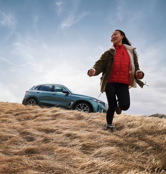 Front side angled view of BMW vehicle with women on field