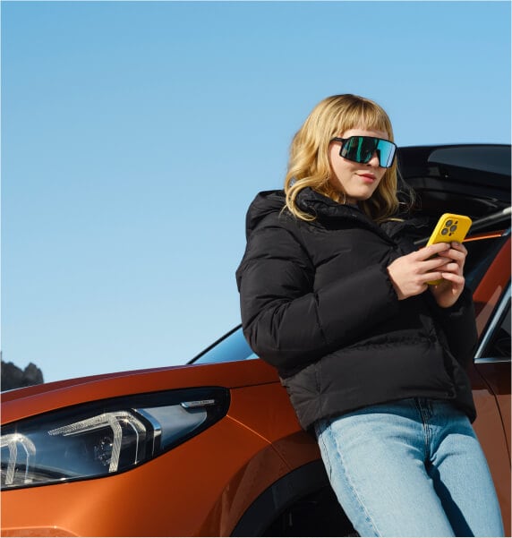 Woman on a phone leaning on BMW vehicle