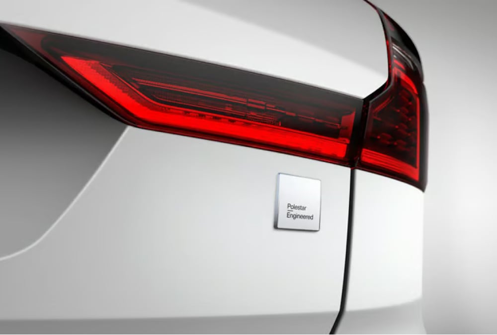 Close-up of the rear left taillight and badge on a white car, showing the label Polestar Engineered