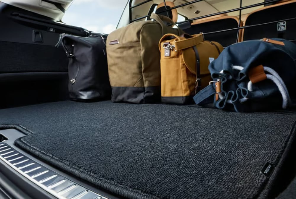 Car trunk with four bags lined up against the backseat, showcasing a spacious and clean cargo area