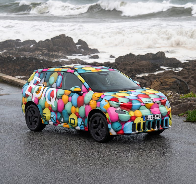 Front angled view of Skoda Epiq with ocean and background