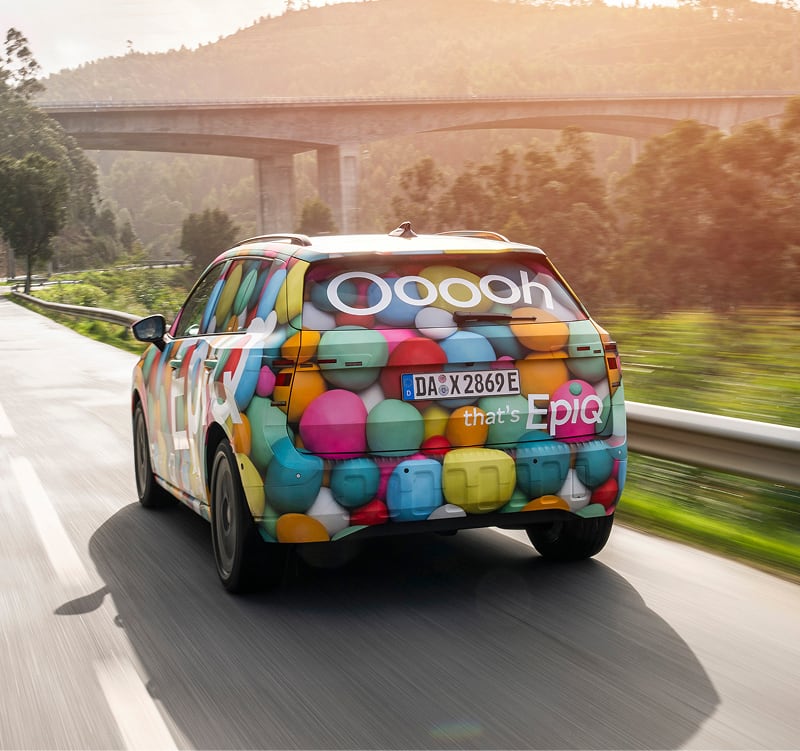 Rear view of Skoda Epiq on the road with bridge background