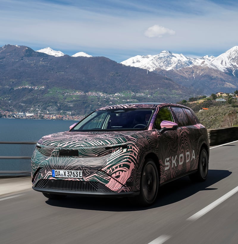 Front angled view of a Skoda Peaq driving on a mountain road in the background