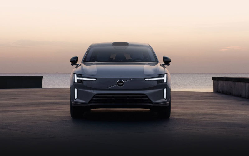 Front view of the Volvo ES90 parked at a waterfront at dusk