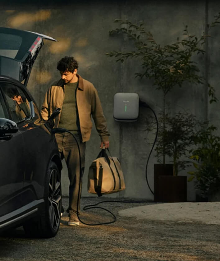 Rear view of Volvo EX60 open boot and charger